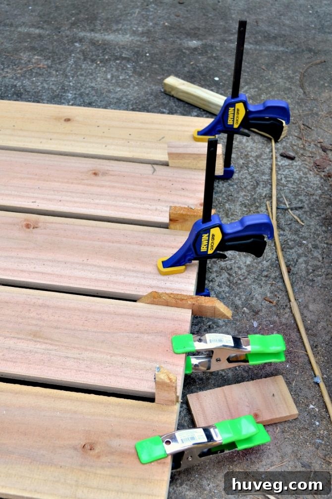 Clamps hold the boards of the panel in place as they fuse to the post