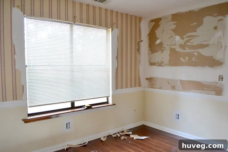 Close-up view of dining room wallpaper being removed, showing the meticulous process.