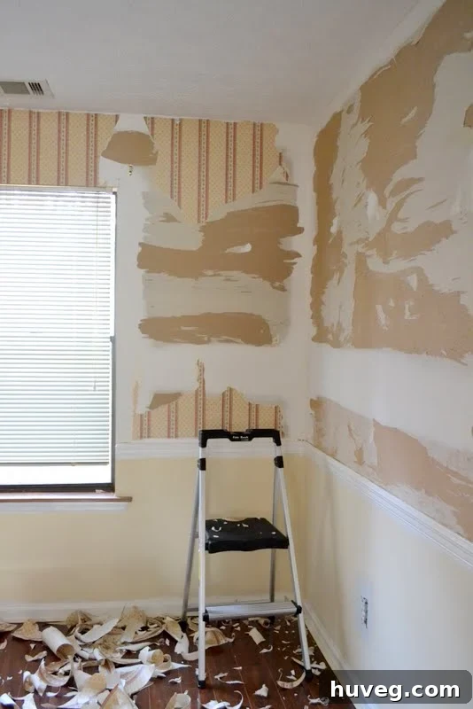Another perspective of dining room wallpaper being stripped from the wall.