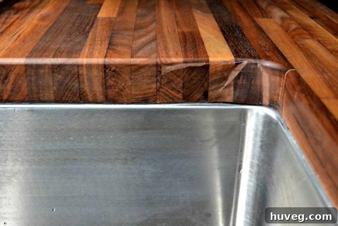 Close-up of the inside curve of an undermount sink, showing a repaired cut issue in the countertop