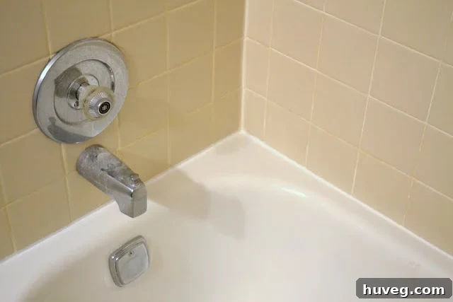 Newly caulked shower with a clean, sealed edge and a new shower head