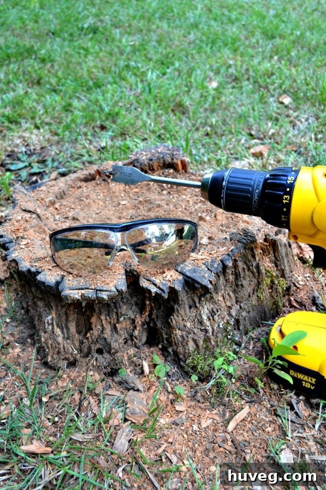 Close-up of safety goggles and a power drill on a wooden surface