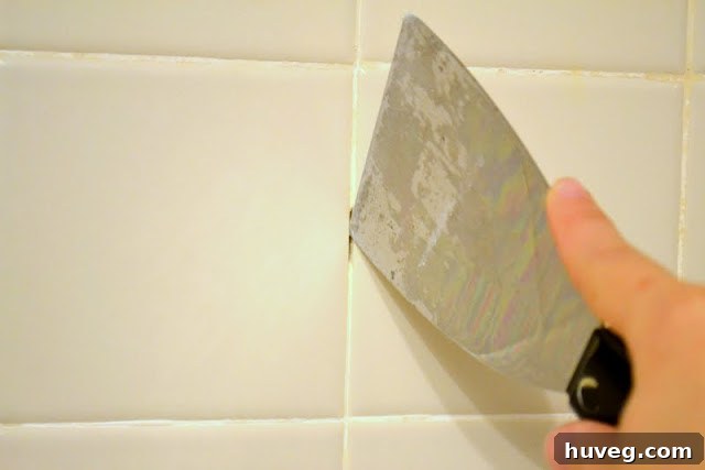 Silicone caulk used to patch missing grout between tiles